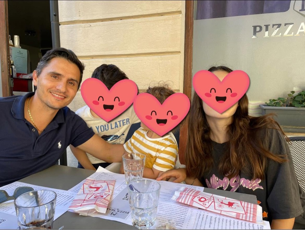 Giacomo attablé avec ses trois enfants à la terrasse d'une pizzeria, leurs visages masqués